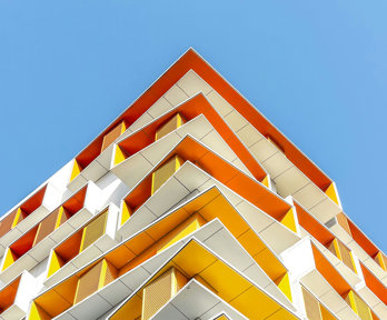Modern building painted in white and various shades of yellow and orange.