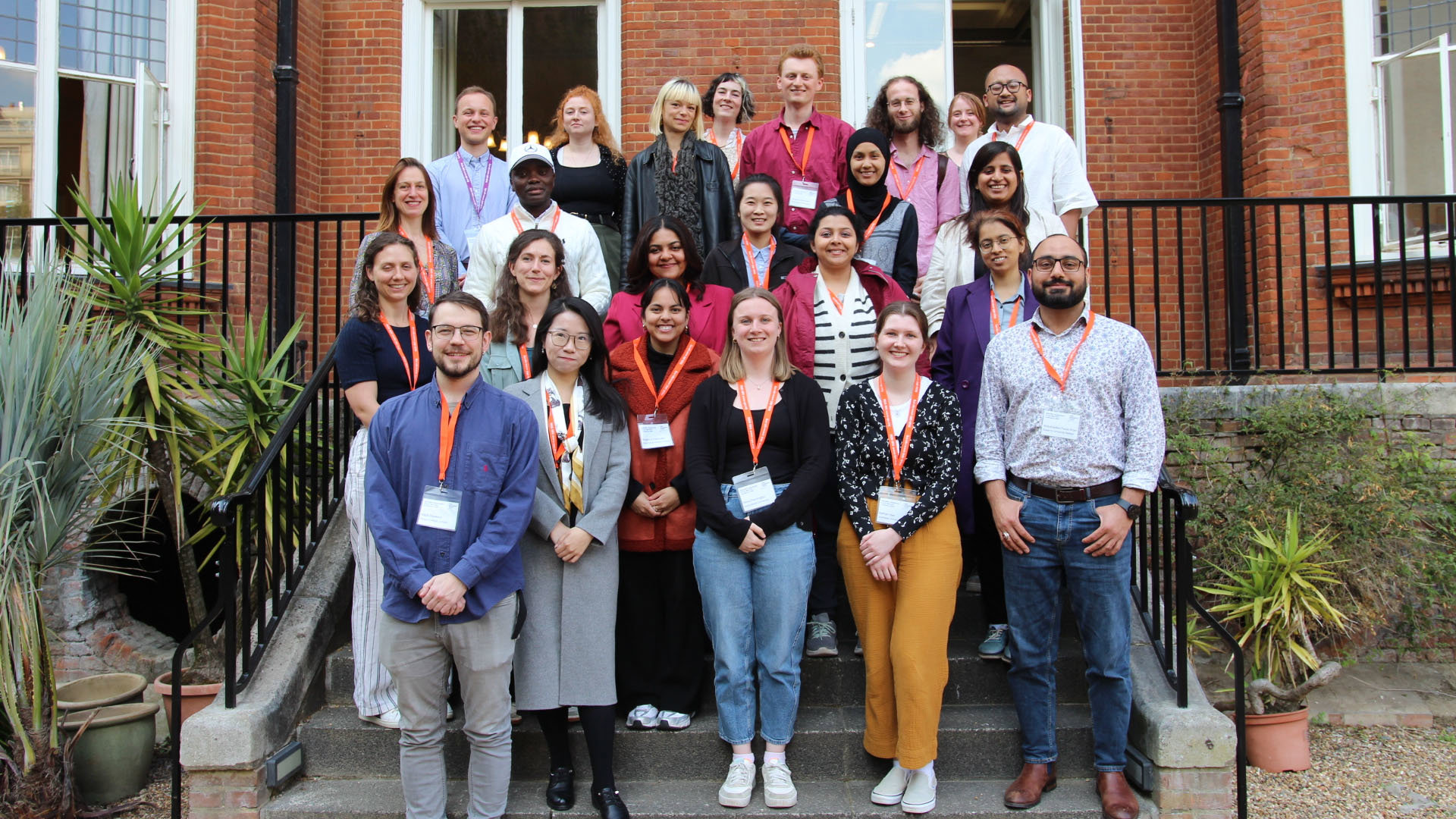 A large group of people posing on a set of stairs in front of the Royal Geographical Society's terrace.
