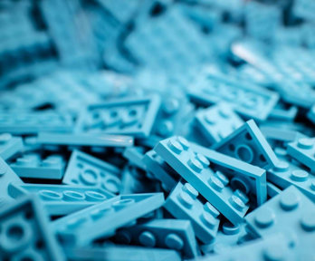 A pile of blue, rectengular lego blocks.