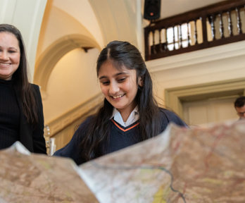 A young person looking at a large map.