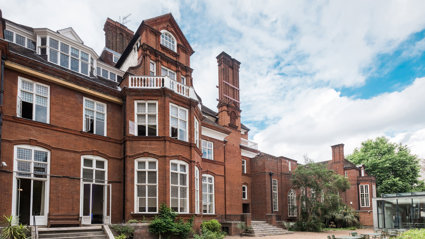 Rear view of the red-brick Royal Geographical Society building from the back terrace, featuring classic architectural details.