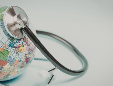 Global health care concept with stethoscope on world globe.