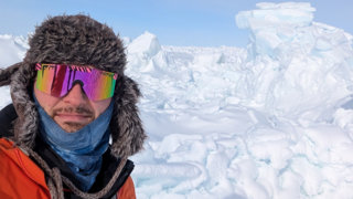 Robbie Mallett taking a self in the snow, wearing a hat and glasses.