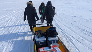 The team pulling equipment along the snow.