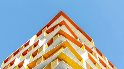 Modern building painted in white and various shades of yellow and orange.