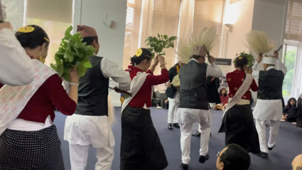 People in Indigenous Himalayan clothing doing a dance for an audience.