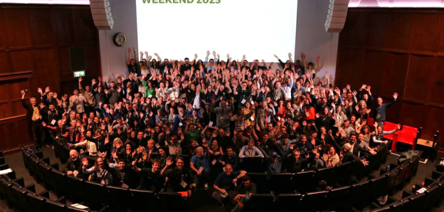 Delegates in the Ondaatje Theatre at the RGS Explore Weekend 2025, waving their hands in the air,