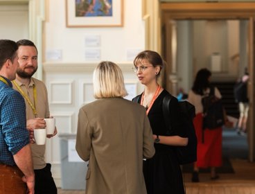 Four people networking at Annual Conference at the Royal Geographical Society.