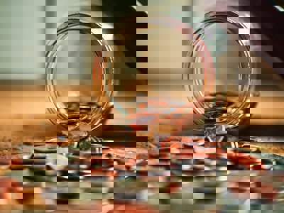 Assorted coins coming out of a jar