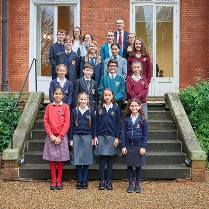 A selection of students who have won the Young Geographer of the Year competition standing on the steps of the Royal Geographical Society