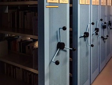 A row of blue metal archive shelves containing books.