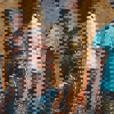 A group of Africa children looking to camera. One girl is focused on particularly and she is smiling