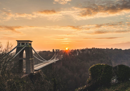 Bridge over a goirge with a sunset background