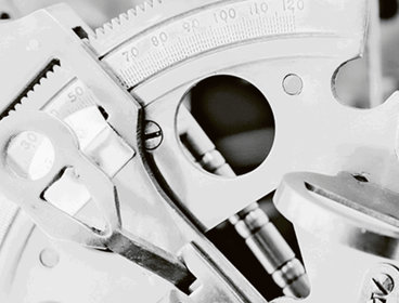 Close-up of a metal cog showing measurements in monochrome.