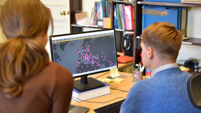 Two apprentices working on a computer together, using GIS
