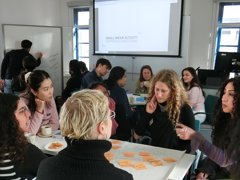 A group of people having a discussion around a table of post-it notes