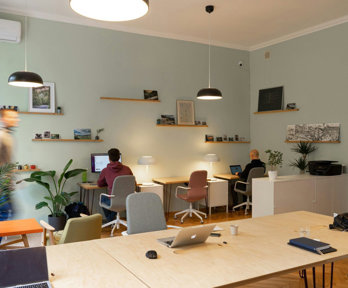 Multiuse small office with two people working behind computers.