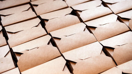 Folded cardboard boxes stacked in rows.