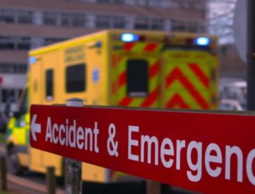 Accident and emergency sign outside a hospital with ambulance.