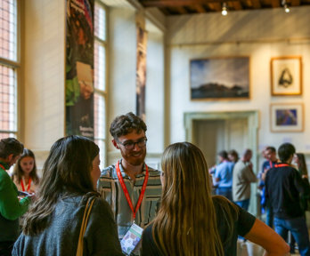 Conference attendees networking in the Main Hall at the Royal Geographical Society.