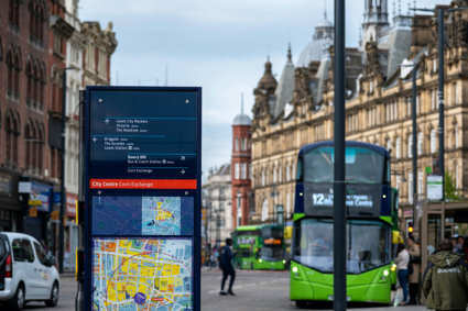 Sign with map and green bus in town centre