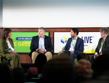 Four people sitting on panel on stage.