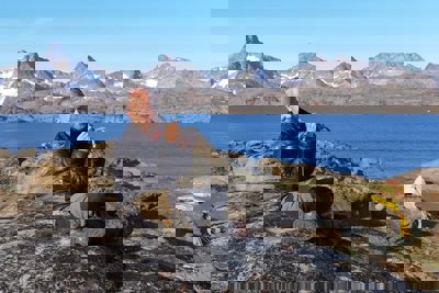 Richard Philips in Greenland, sitting on a rock