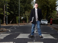 Ed Parsons standing on a crossing holding a laptop.