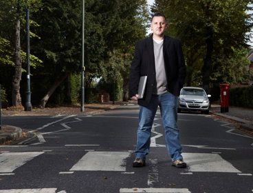 Ed Parsons standing on a crossing holding a laptop.