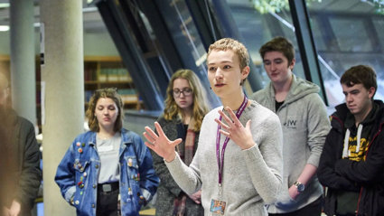 Person giving a talk to students in areading room.