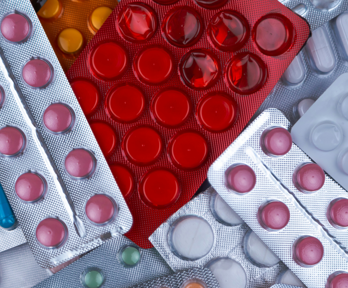 Empty, partially empty and full packs of pills and tablets thrown on top of each other.