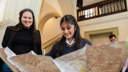 A young person looking at a large map.