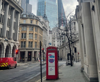 London financial district in the day. Skyscrapers and a phone box can be seen.