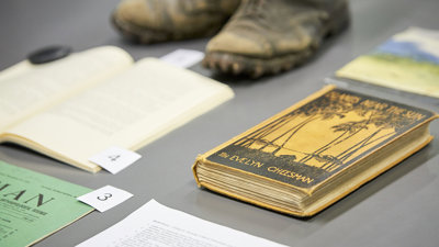 Display of historic materials including worn boots and books.