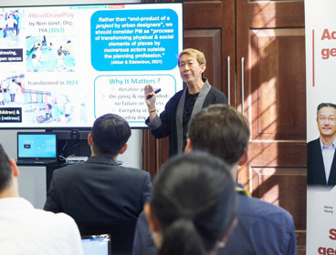 A conference delegate presenting a slide to other conference delegates.