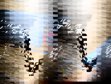 A cyclist in a union jack tunic riding a bicycle around a velodrome track