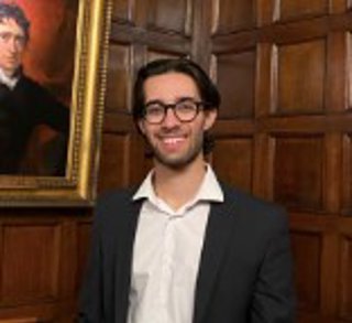 Oscar McDonald standing in front of painting.