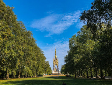 Hyde Park with two lines of large trees and the Albert Memorial in the centre.