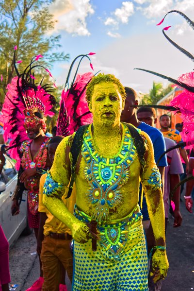 A man at mardi gras covered in colourfuul body paint