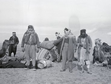 Black and white photohraph of travellers in a desert by Gertrude Bell.