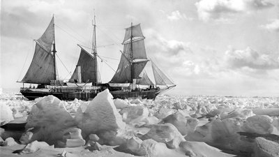 Photograph in black and white showing the sideview of the Endurance sailing ship manouvering through ice floes in the Arctics.