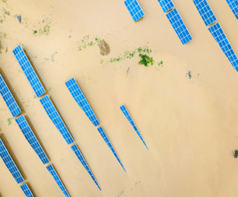 Tops of solar panels sticking out of the water in a flooded area.