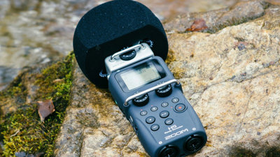 Hand-held microphone layingon a rock in a river.