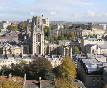 Aerial view of the University of Bristol campus with a prominent Gothic-style tower surrounded by autumn trees and academic buildings.