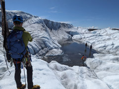 Grant recipient standing next to a glacial lake during fieldwork
