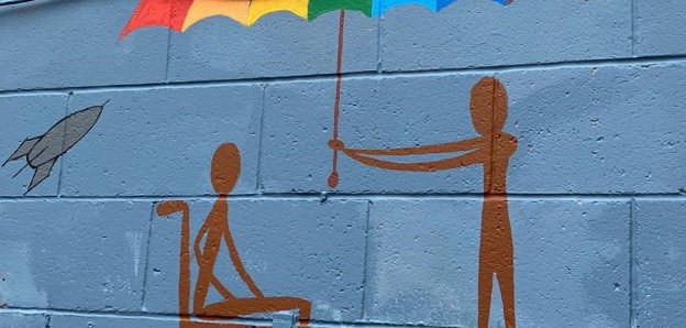 A mural artwork showing a wheelchair user and a person holding an umbrella above their head