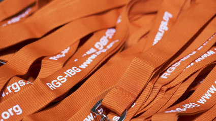 Pile of orange conference lanyards with white lettering reading RGS-IBG.