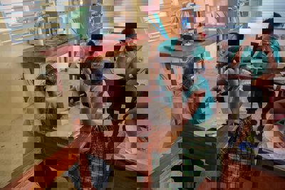 An adult helps a child with their school work in a school