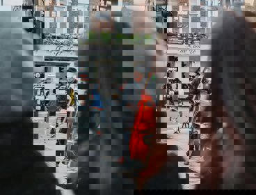 A person playing a double bass on the street with people watching