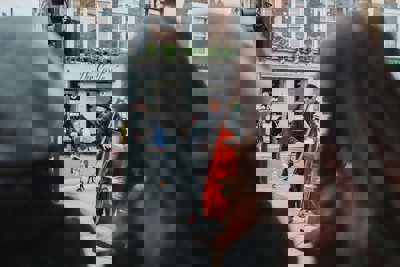 A person playing a double bass on the street with people watching